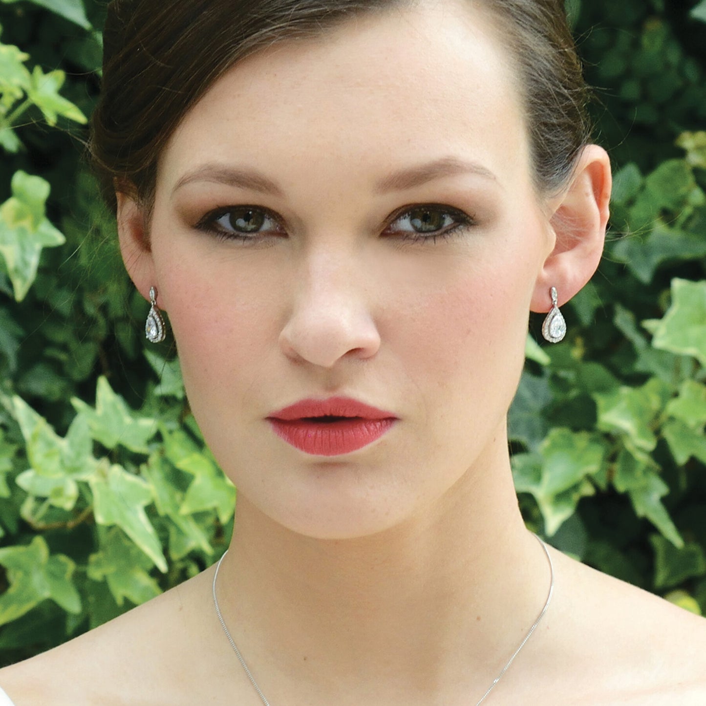 Belmont øredobber er laget av en delikat design av asfalterte steiner som omgir en riveskåren stein. Veldig elegant i sin enkelhet og en veldig allsidig design som passer til mange forskjellige brudekjolestiler. Belagt i Rhodium i en høyglans finish. Med en tradisjonell ørepyntstolpe og 2 cm på det lengste punktet.