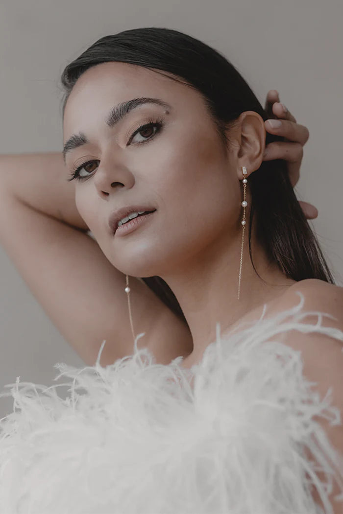 Lange øredobber med et delikat design. Hver øredobb er dekorert med tre små, høykvalitets ferskvannsperler og glitrende krystaller i en strålende kuttstil. Disse øredobbene er virkelig et blikkfang, spesielt på grunn av deres mengde og de subtile glitrende krystallene som rammer inn brudens ansikt på en perfekt måte uten å ta for mye oppmerksomhet.