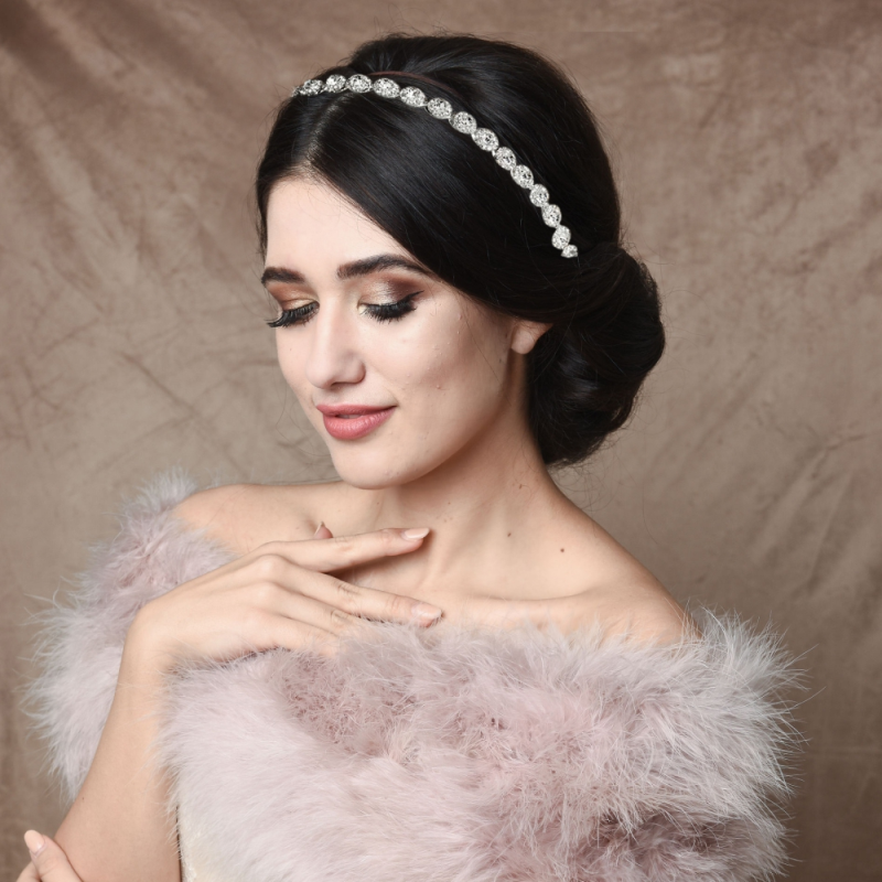 Vakker hårpynt i sølv med crystaller. Hårpyntet har silkebånd i elfenben slik at den enkelt kan festes i håret. Alternativt fjerner man disse enkelt for usynlig feste i håret med hårnåler. Vakker som tiara eller rundt en hårknute. Det perfekte tilbehøret til din brudekjole.