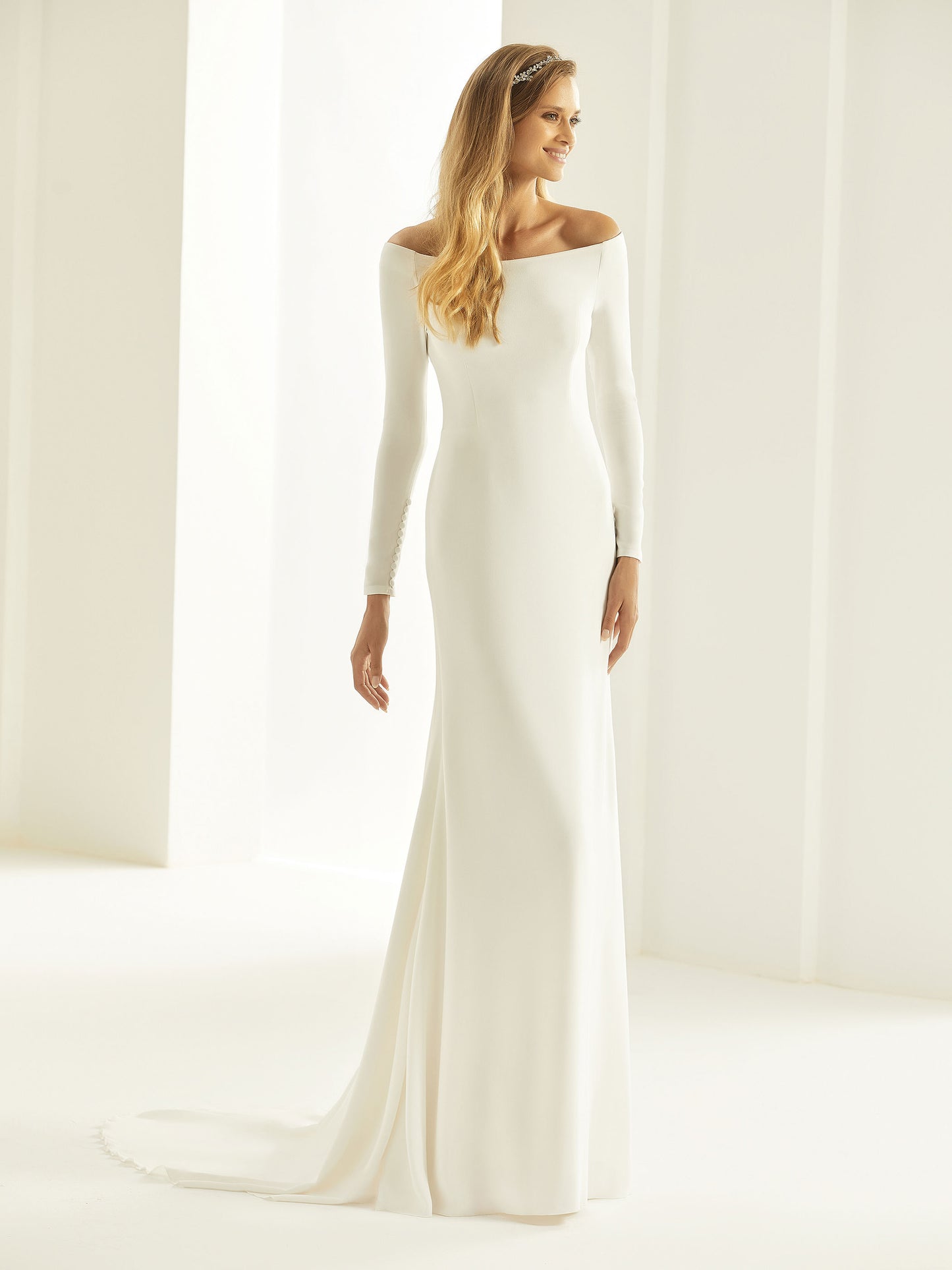 Nydelig Brudekjole inspirert av den populære Meghan Markle-brudekjolen. I et lett Georgette materiale. Off-shoulder, lange ermer og vakker blonde rygg.