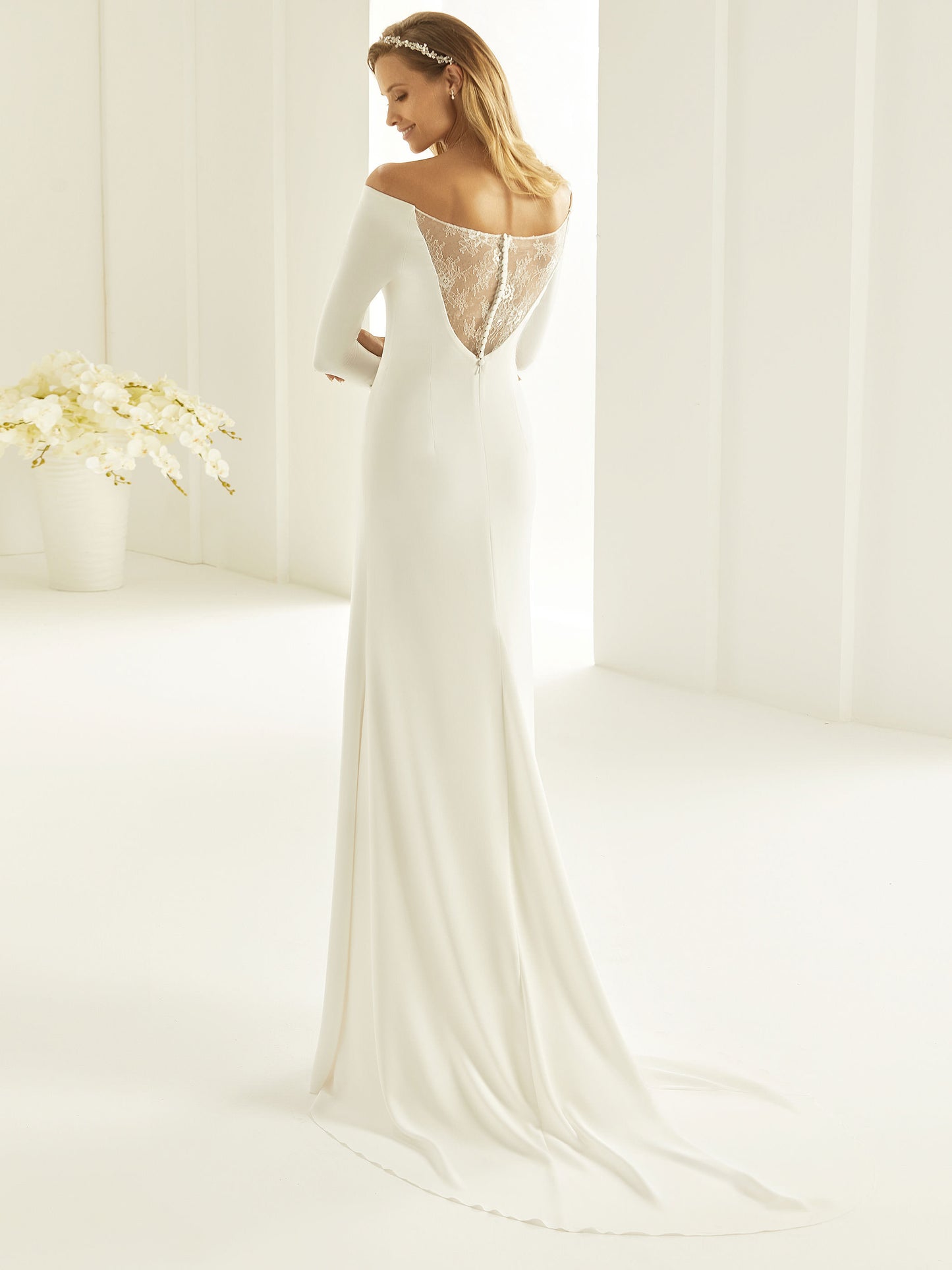 Nydelig Brudekjole inspirert av den populære Meghan Markle-brudekjolen. I et lett Georgette materiale. Off-shoulder, lange ermer og vakker blonde rygg.