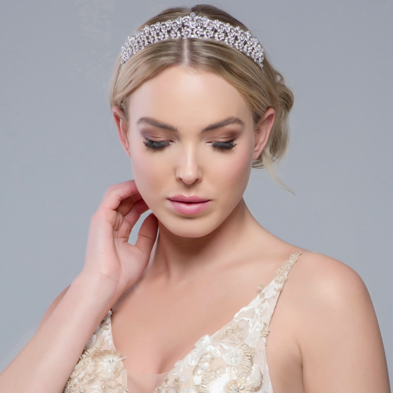 Klassisk og vakker tiara i sølv med glitrende krystaller. Tiaraen har en høyde på ca. 2,5cm. Sitter godt på hodet og gir en elegant detalj til brudeantrekket ditt.