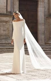 Nydelig Brudekjole inspirert av den populære Meghan Markle-brudekjolen. I et lett Georgette materiale. Off-shoulder, lange ermer og vakker blonde rygg.