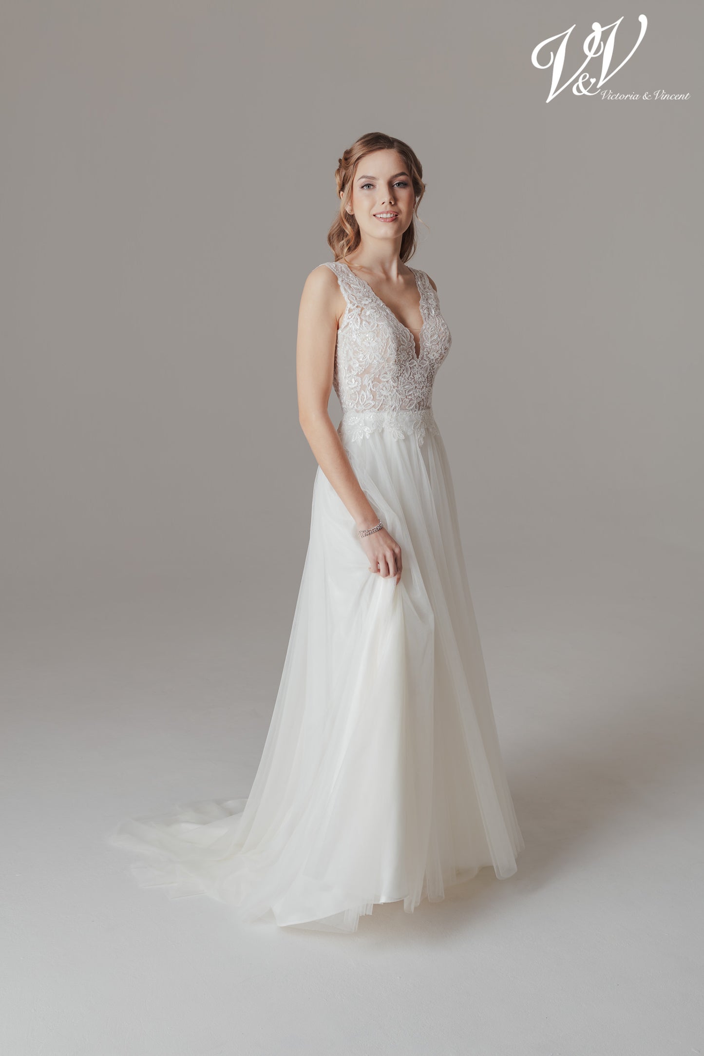 Vakker vintage-inspirert brudekjole med A-line skjørt og nydelig blonde-topp v-hals. Toppen har blonder i ivory over et underlag i nude farge som gir en fin illusjon. En lett og elegant kjole med flotte detaljer.