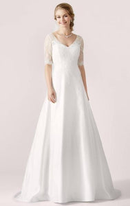 En flott, stilren brudekjole, med halve ermer i blonde, og et skjørt i sateng med a-linje passform.
