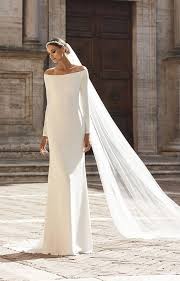 Nydelig Brudekjole inspirert av den populære Meghan Markle-brudekjolen. I et lett Georgette materiale. Off-shoulder, lange ermer og vakker blonde rygg. 